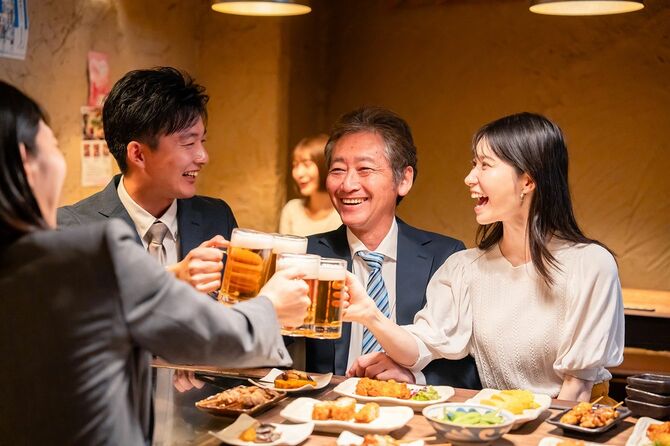 居酒屋で乾杯する男女のビジネスパーソン