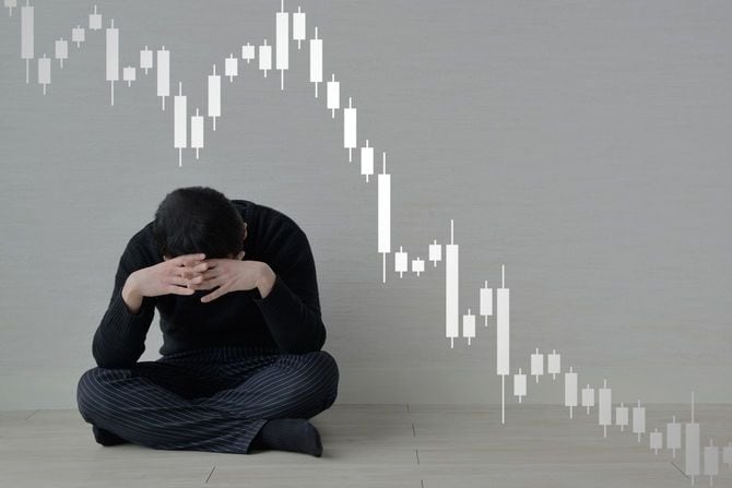 株価チャートの下落を心配する男性