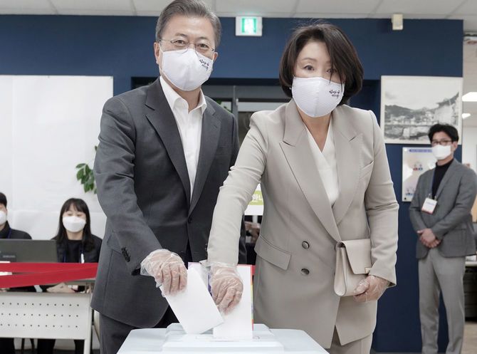 2020年4月10日、手袋にマスク姿で、妻と共に期日前投票を行う文在寅大統領。