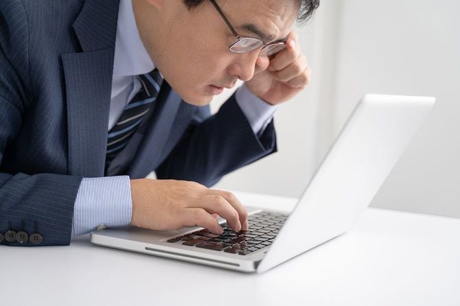 オフィスでノートパソコンを見る男性