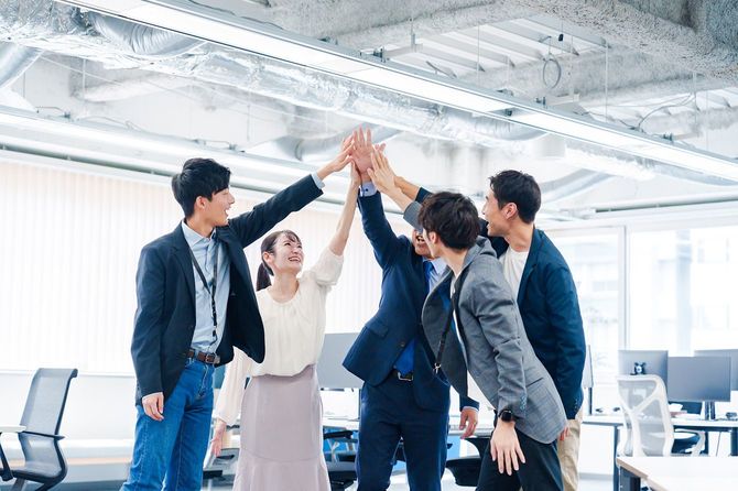 オフィスでハイタッチをするビジネスパーソン