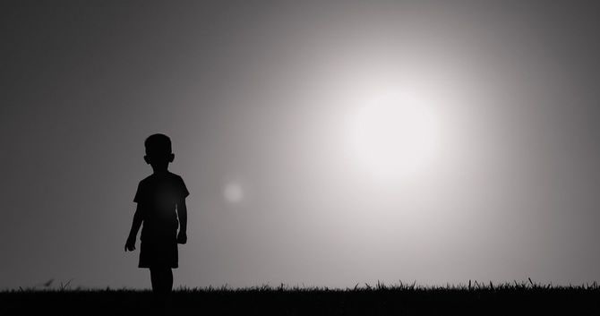 野原を歩く小さな子供のシルエット