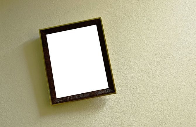 セメントの壁に掛かる木製の額縁