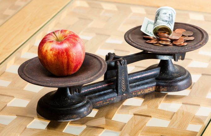 天秤にかけられているコインとりんご