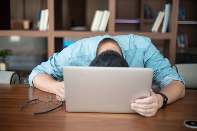 パソコンの前でうなだれる疲れた男性