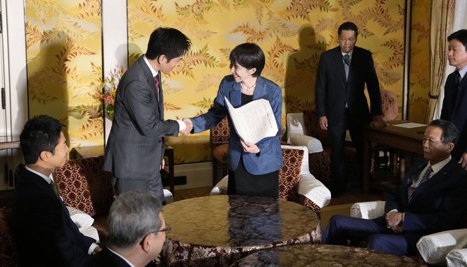 連立政権合意書に署名し、握手する自民党の高市総裁(右)と日本維新の会の吉村代表=2025年10月20日午後、国会