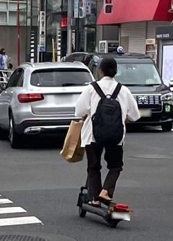 交通量の多い車道を走るキックボード