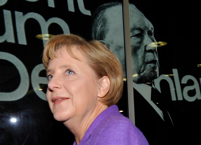 CDU党本部にあるアデナウアー元首相の写真の前を通るメルケル首相（2009年9月28日）