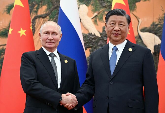 2023年10月18日、中国・北京の人民大会堂で、第3回「一帯一路」国際協力フォーラムの一環として行われた会談の前に握手するロシアのプーチン大統領（左）と中国の習近平国家主席。