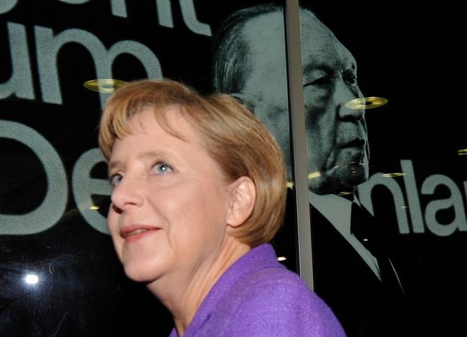 CDU党本部にあるアデナウアー元首相の写真の前を通るメルケル首相（2009年9月28日）