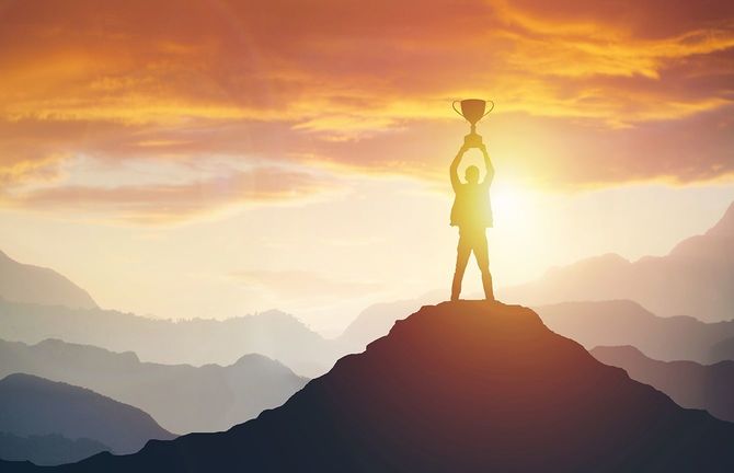 夕暮れ時にトロフィーを持つ男のシルエット