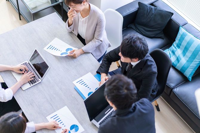 オフィスで楽しそうにミーティングをする人たち