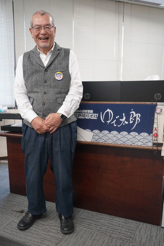 ゆで太郎システム本社の社長室で撮影に応じる池田社長