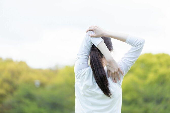 運動前に準備運動をしている若い女性
