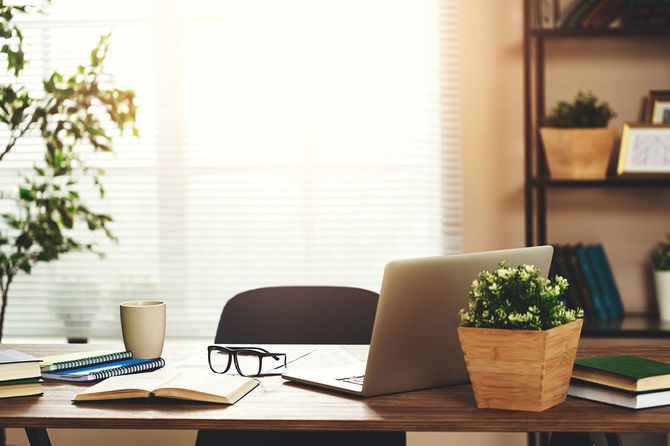 アパートの自宅のオフィスの窓にコンピュータを持つ職場デスク