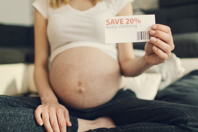 ベビー服のクーポンを持つ妊婦
