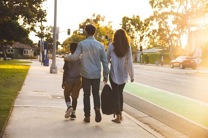 ロサンゼルスの歩道を歩く家族