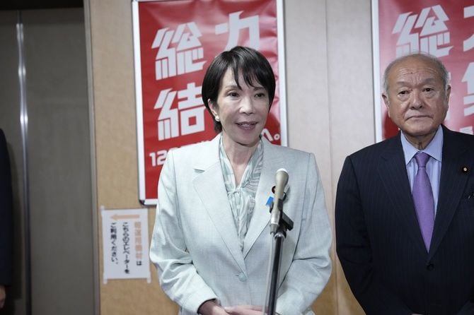 自民党本部で記者団の取材に応じる高市総裁。右は鈴木幹事長＝2025年10月7日午後、東京・永田町