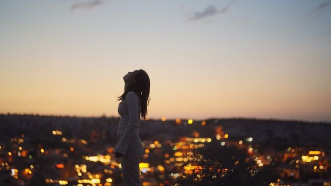 崖の端に立つ若い女性観光客