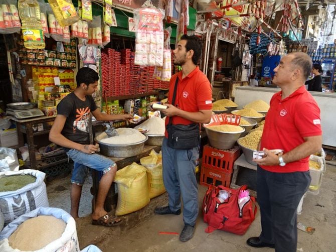 カイロの市場でセールスマンと一緒に営業をする宇治弘晃氏(右)