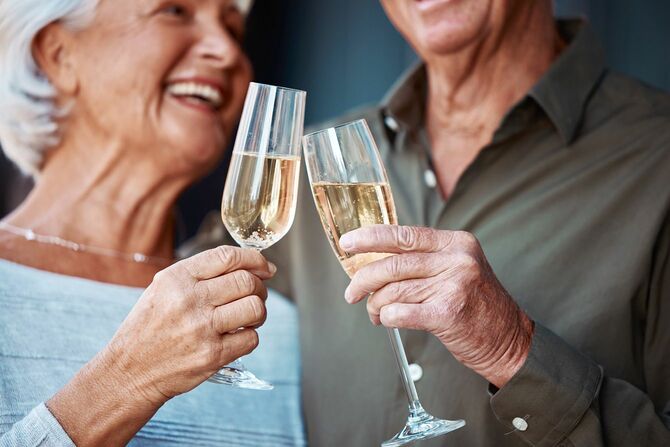 シャンパンで乾杯する高齢のカップル