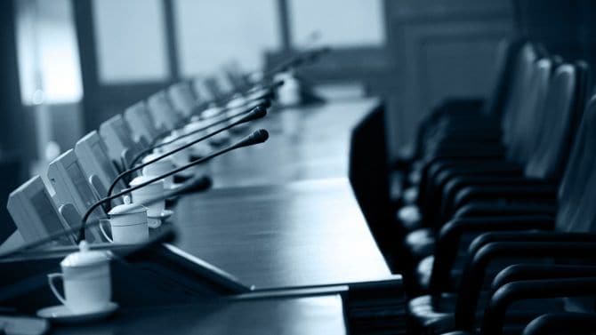 各席にインカムが置かれた空席の役員室