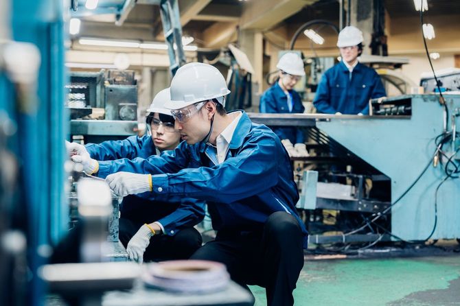 工場で機械を整備する労働者