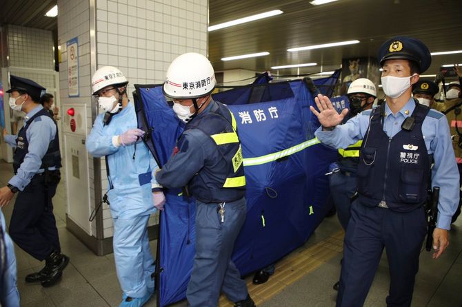 小田急線祖師ケ谷大蔵駅から負傷者を運び出す救急隊員ら＝2021年8月6日夜、東京都世田谷区