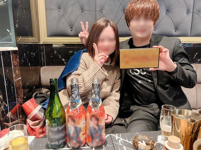 シノブさんと写真に収まるホストの男性A=2023年12月、愛媛県内のホストクラブにて
