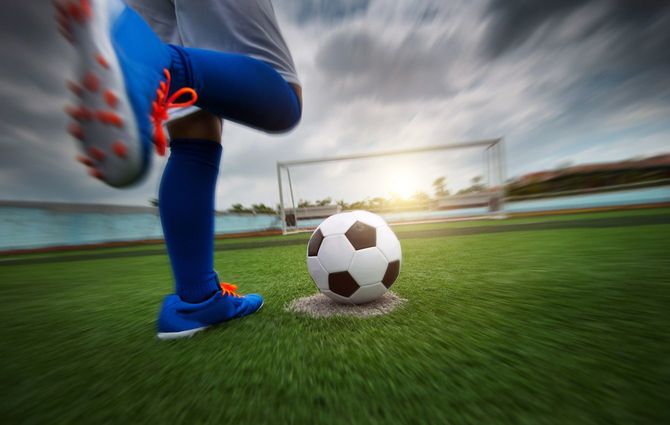 サッカーボールを蹴る少年の足