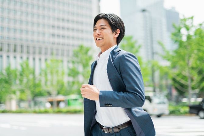 横断歩道を横切って走るビジネスマン
