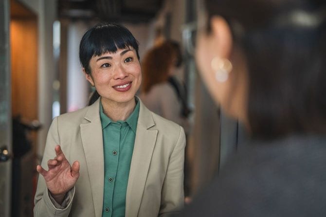 オフィスで同僚と話す女性