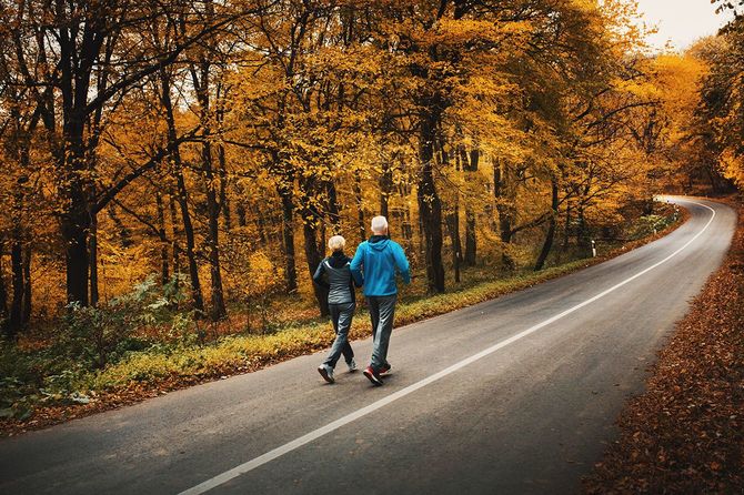 森の中でジョギングをするシニアカップル。