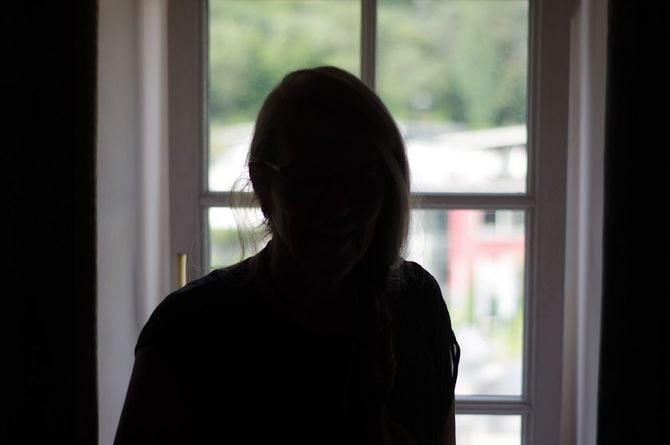 窓辺に立っている女性のシルエット