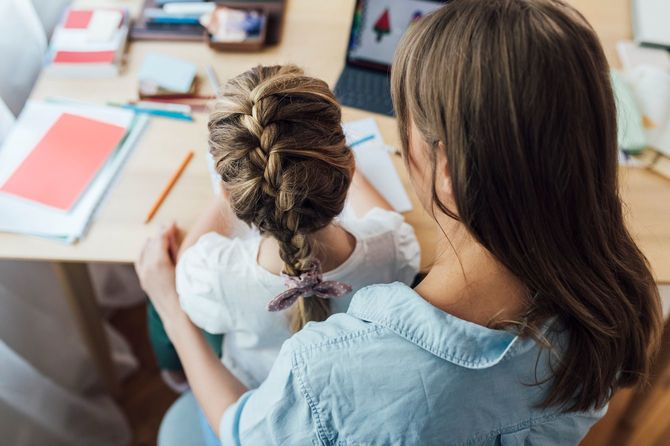 母親の膝の上に座って、お絵かきする少女
