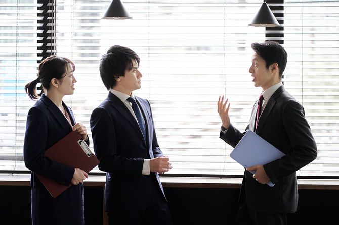 オフィスで議論するアジアのビジネスパーソン