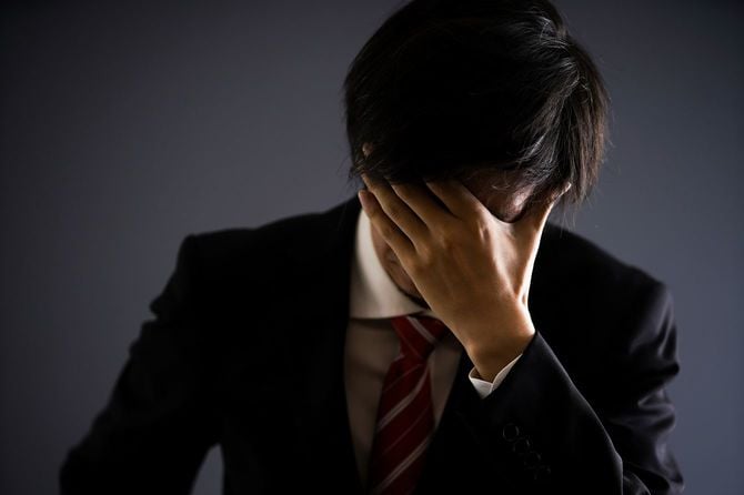 頭を抱えている男性