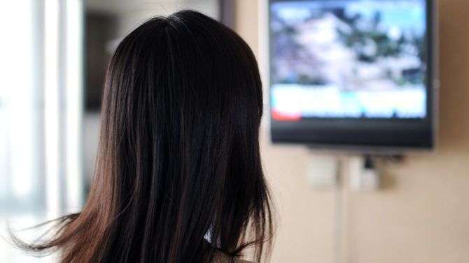 テレビを見つめる女性
