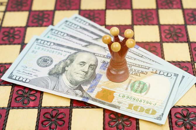 ビジネスと成功の概念。チェスボードには赤い王が立っているお金があります。