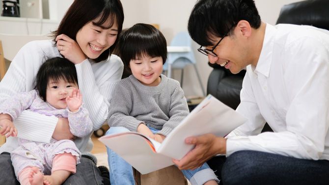 子どもたちに読み聞かせをする父親