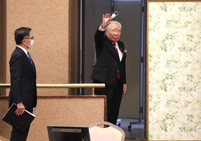 スズキの株主総会で会長退任のあいさつを終え、会場を後にする鈴木修氏（右）。左は鈴木俊宏社長＝2021年6月25日、浜松市［同社提供］