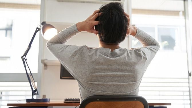 在宅勤務中に頭を抱える男性