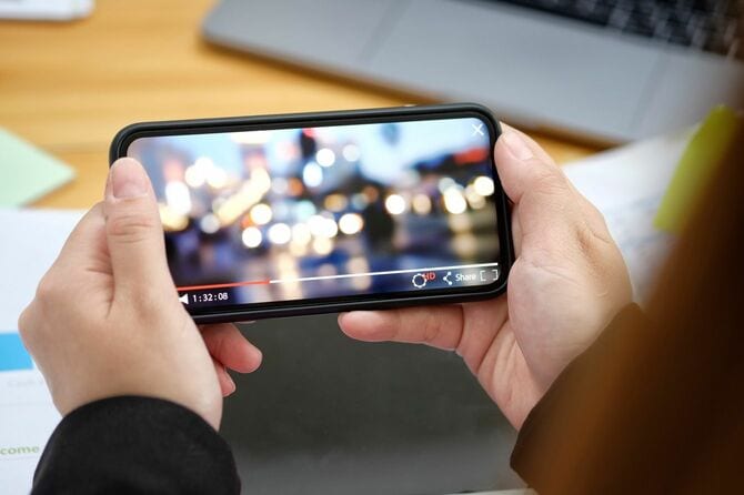 スマートフォンで動画を見る人の手