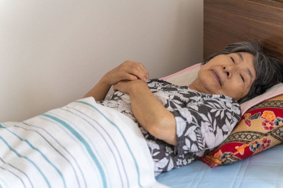 ベッドに横たわる高齢女性
