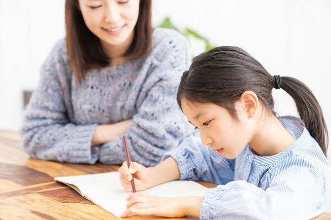 勉強するアジア人の親と娘