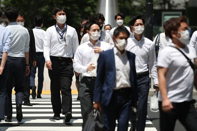 真夏日を迎えた東京・大手町でマスク姿で歩く人たち＝2020年6月9日