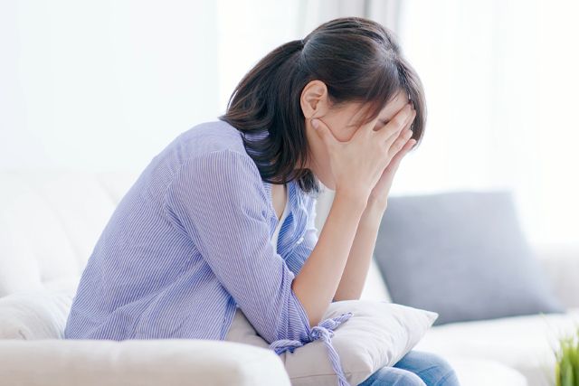 顔をおおう女性