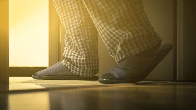パジャマ姿で歩く男性のスリッパをはいた足元