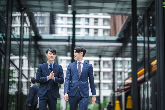 ビジネスマンが二人並んで歩く