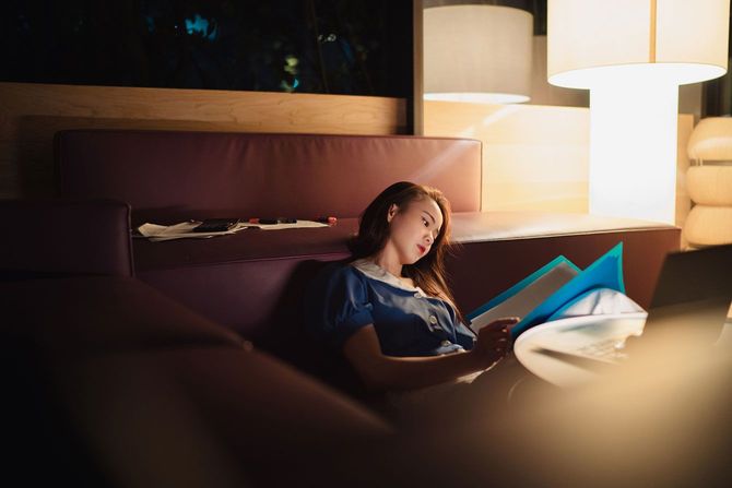 薄暗い部屋で書類を見ている女性
